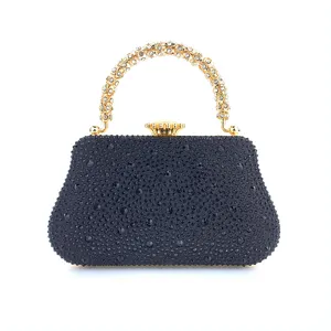 Vue de détail de pochette de soirée en strass, sac noir en cristal avec poignée dorée.