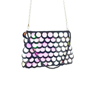 Detailed view of women evening clutch bag with gradient sequin fish scales and metal chain.
