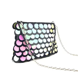 Detailed shot of gradient sequin clutch bag with chain and beaded handle for evening party.