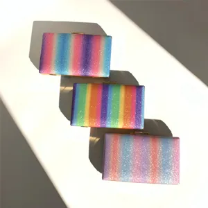 Close-up detail of glittering rainbow striped clutch bag featuring a sleek gold metal frame lock.