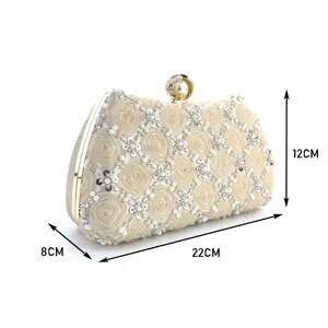 Detail view of beige beaded evening clutch bag with rose pattern and gold frame hardware.