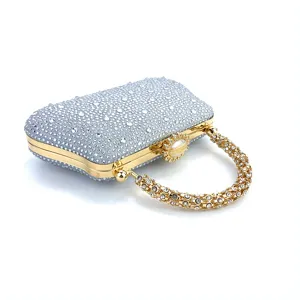Élégante pochette de soirée argentée en strass avec quincaillerie dorée et poignée chic.