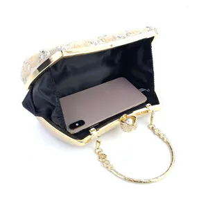 Detailed view of the elegant beaded evening clutch with gold frame and metal handle capacity.