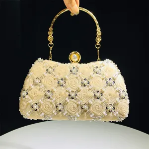 Elegant champagne evening clutch with fabric rosettes, beaded lattice and gold metal handle.