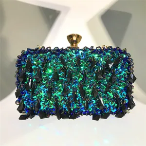 Detailopname van de blauw-groene pailletten avondtas met kralen en zwarte geometrische hangers.