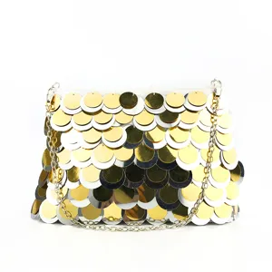 Detail shot of sequin evening clutch bag featuring gold and silver discs and metal chain.