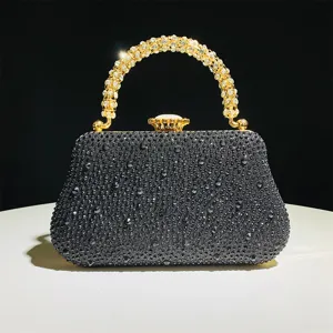 Pochette de soirée exquise en strass noir avec poignée dorée étincelante et fermoir métallique.
