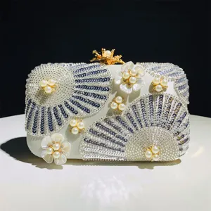 Exquisite beaded clutch bag detail featuring floral pearl embroidery and gold clasp.