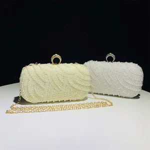 Detailed view of elegant pearl evening clutch bags with chain straps and glittering ring clasps.