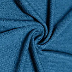 Detailed view of dark blue textured knit fabric, breathable material surface with swirl drape.