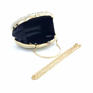 Details van elegante schelp avondtas met strass steentjes en een gouden ketting.