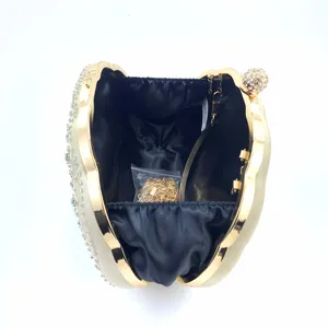 Details van de prachtige strass schelp avondtas, elegante gouden frame met ketting.