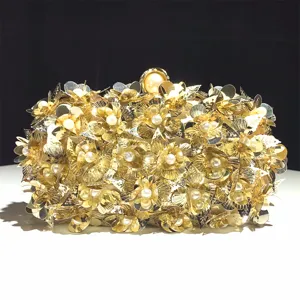Detailed close-up view of gold sequin floral evening clutch bag with pearl embellishment