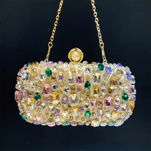 Close-up detail of luxury rhinestone evening clutch bag sparkling colorful crystals gold chain.