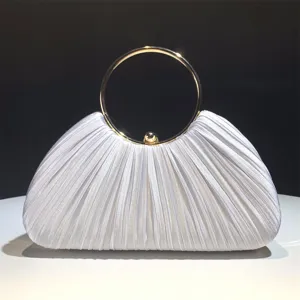 Detailed view of the white pleated satin evening clutch with a polished gold metal ring handle.