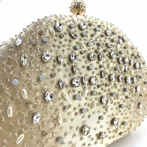 Gedetailleerd overzicht van luxe champagne avondtas met sprankelende kristallen en parels.