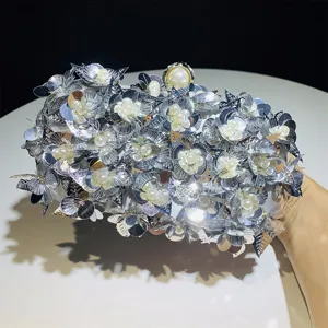 Detail view of a luxurious silver sequin evening clutch bag adorned with elegant pearls.