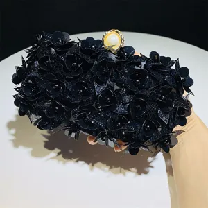 Black floral sequin evening clutch detail showing intricate petal texture and pearl clasp.