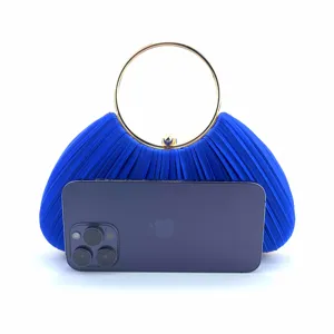Detail view of royal blue satin pleated evening clutch with elegant gold ring handle.