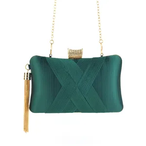 Dark green satin evening clutch detail featuring pleated fabric, gold chain and shiny crystal clasp.