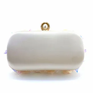Detail view of a luxury satin evening clutch bag with pearl clasp and gradient flower decor.
