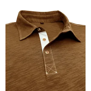 Men's brown cotton polo shirt collar detail view, showcasing fine stitching and buttons.
