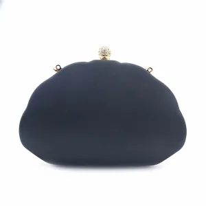 Detailopname van de elegante avondtas van donkerblauwe satin met schitterende strassbolsluiting.
