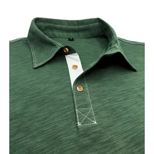 Detailed view of men's cotton polo shirt collar, wooden buttons and contrast stitching.