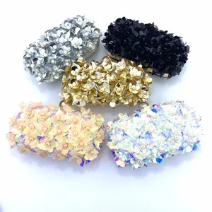 Detail view of luxurious evening clutch bags with heavy 3D sequin flowers and pearl accents.