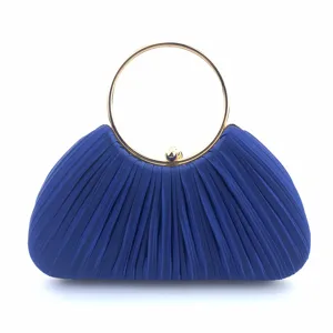 Close-up detail of royal blue satin pleated evening clutch bag with gold round metal handle.