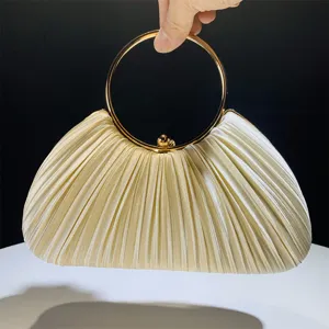 Detailed view of the champagne satin pleated evening clutch featuring a stylish gold ring handle.
