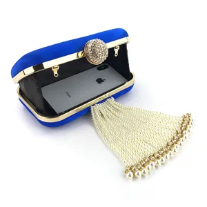Blue velvet evening clutch bag detail showing sparkling rhinestone clasp and pearl tassel.