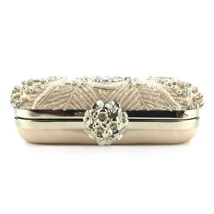 Close-up of exquisite handmade beaded evening clutch bag with elegant metallic floral clasp.