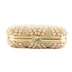 Handmade pearl evening clutch bag detail shot, gold metal frame with rhinestone clasp.