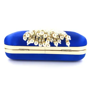 Detail view of royal blue satin evening clutch bag with pearl rhinestone tassels.