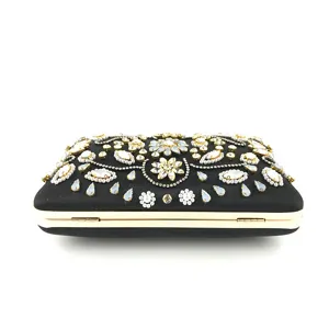 Pochette de soirée brodée de perles et strass avec cadre doré, détail élégant et finition soignée.