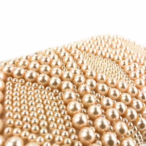 Close-up detail shot of handmade pearl beaded evening bag, showing exquisite texture and design.
