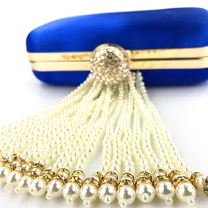 Royal blue satin evening clutch bag with sparkling rhinestone clasp and cascading pearl tassels.