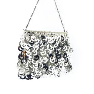 Détail de sac de soirée à sequins argentés avec ornements circulaires brillants et chaîne.