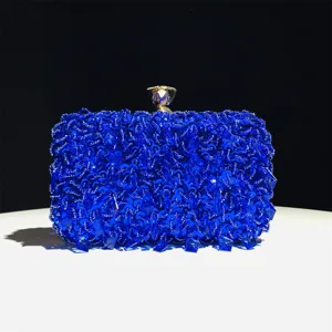 Close-up van de sprankelende blauwe pailletten kralen avond clutch tas met gouden sluiting detail.