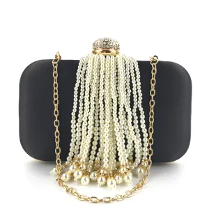 Elegant black evening clutch featuring cascading pearl tassels, rhinestone clasp, and gold chain.
