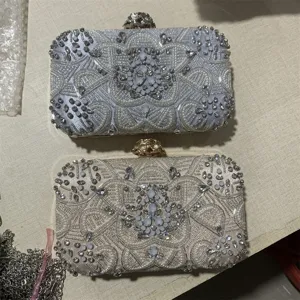 Handcrafted beaded evening clutch bag with sparkling crystals and elegant metallic floral clasp.