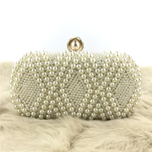 Detailed shot of the elegant handmade pearl evening clutch bag with exquisite gold clasp details.