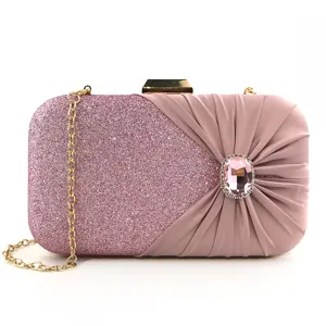 Pink evening clutch bag detail showing glitter fabric, pleated satin, and rhinestone accent.