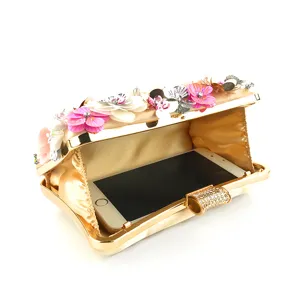 Detail view of gold evening clutch showing interior capacity with handmade floral sequins.