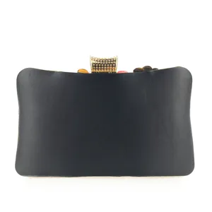 Detailed view of the elegant black evening clutch with gold embellished clasp and floral beading.