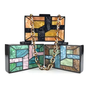 Sac de soirée géométrique en acrylique avec détail de chaîne et motif marbre coloré.