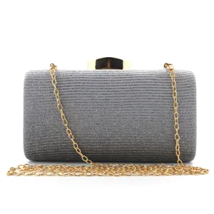 Detailed close-up view of the sparkling grey glitter fabric evening clutch with gold chain.