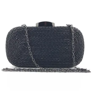 Black woven clutch bag detail view featuring metal chain strap and top clasp hardware.