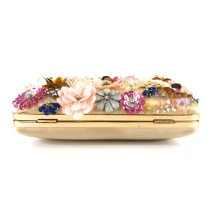 Close-up view of handmade floral sequential evening clutch bag with metallic frame and beading.